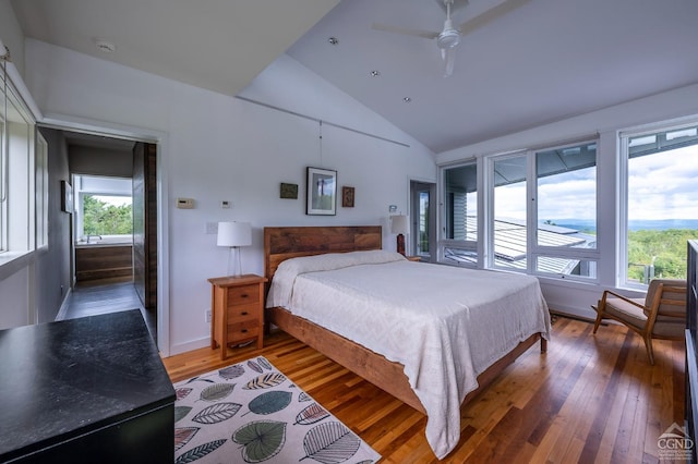 bedroom featuring multiple windows, ceiling fan, dark hardwood / wood-style floors, and lofted ceiling