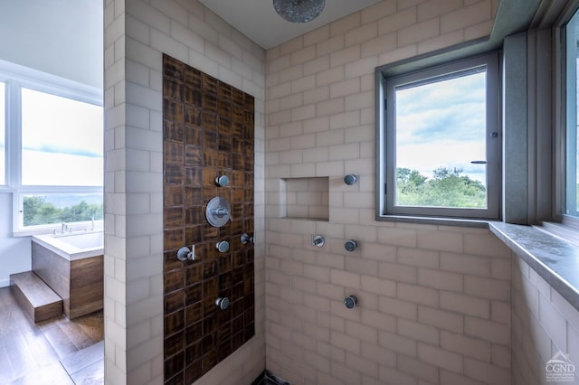 bathroom with wood-type flooring and shower with separate bathtub