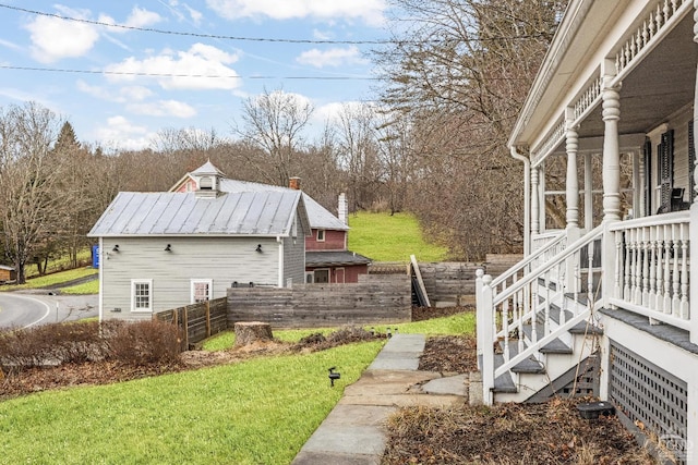 view of side of property with a yard and metal roof