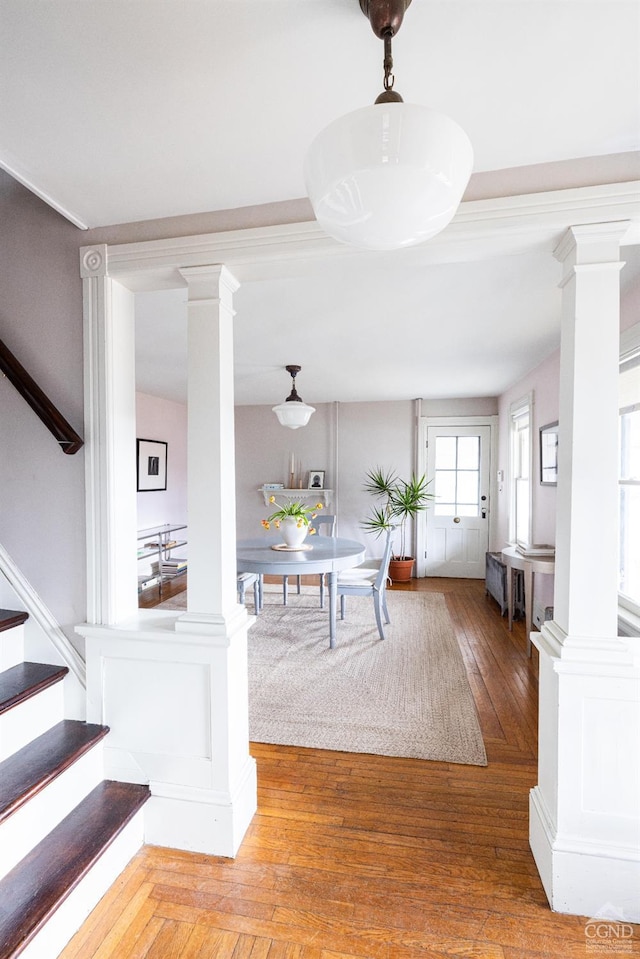 interior space with decorative columns, hardwood / wood-style flooring, and stairway