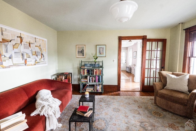 living area with baseboards and wood finished floors