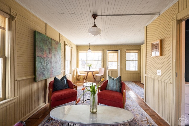 living area with wood ceiling and wood walls