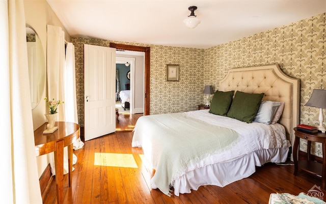 bedroom with wood-type flooring and wallpapered walls