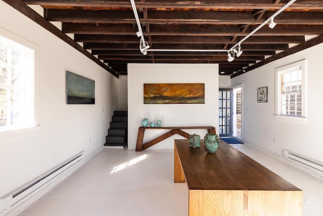 interior space with stairs, a baseboard radiator, and track lighting