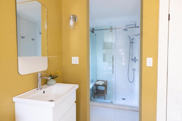 full bath with a tile shower and vanity