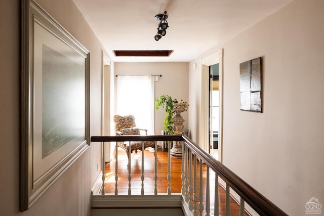 corridor featuring an upstairs landing and wood finished floors