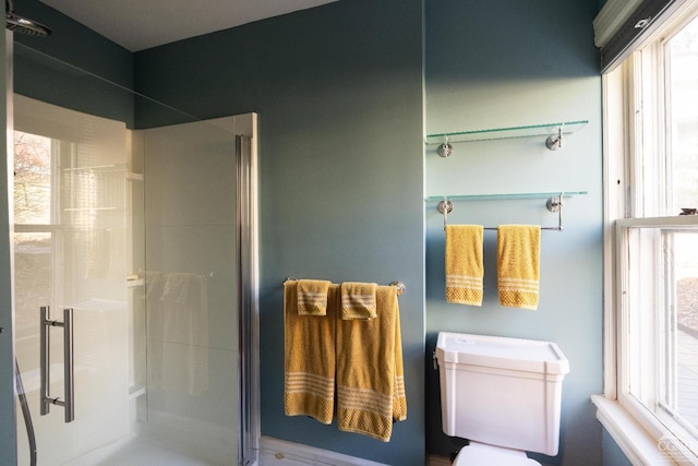 bathroom featuring toilet and a shower stall