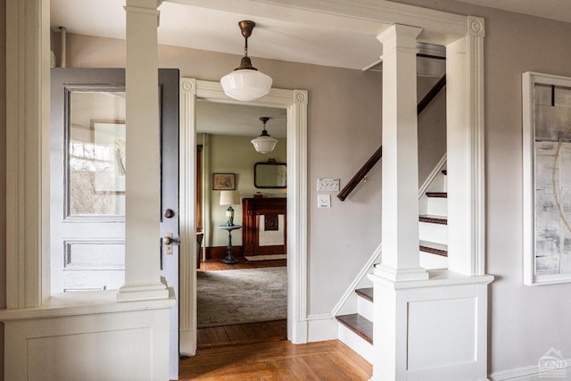 foyer entrance with stairway, parquet floors, and decorative columns