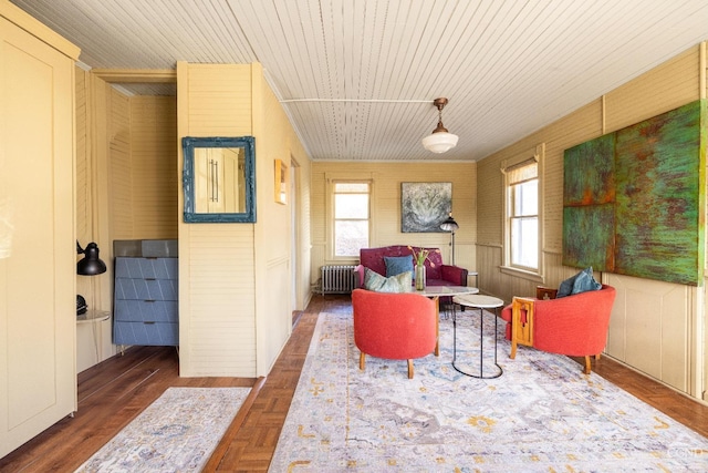 living area featuring a wealth of natural light, parquet floors, wood ceiling, and radiator heating unit