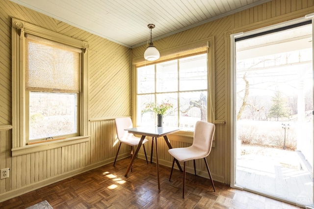 dining room with baseboards and wood walls