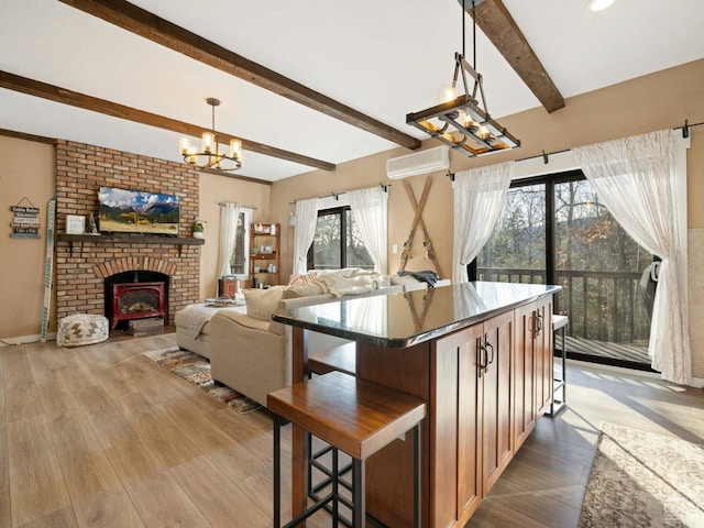 kitchen with a chandelier, a breakfast bar area, open floor plan, light wood finished floors, and decorative light fixtures