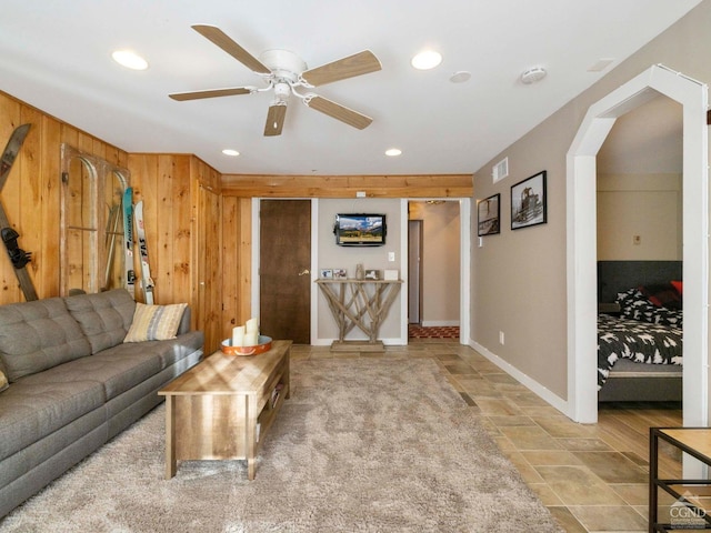 living room with a ceiling fan, recessed lighting, visible vents, and wooden walls