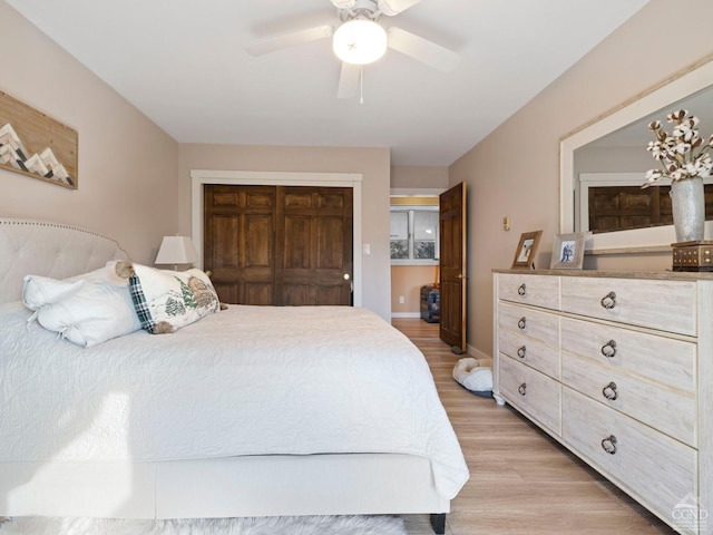 bedroom featuring light wood-type flooring, a closet, ceiling fan, and baseboards