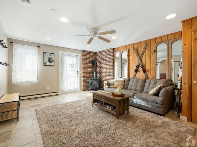 living room with a baseboard radiator, a wood stove, ceiling fan, and recessed lighting