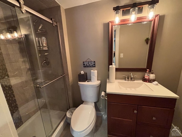 bathroom featuring vanity, a shower stall, and toilet