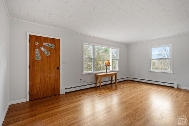 entrance foyer featuring hardwood / wood-style floors, ornamental molding, and a baseboard heating unit