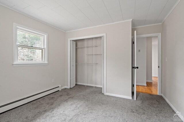 unfurnished bedroom featuring carpet flooring, crown molding, a closet, and a baseboard radiator