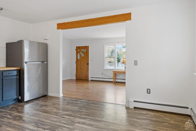 kitchen with beamed ceiling, dark hardwood / wood-style floors, stainless steel fridge, and a baseboard heating unit