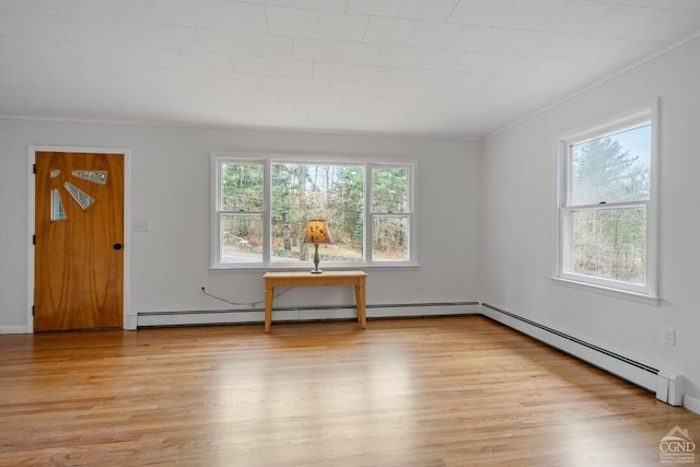 unfurnished room with baseboard heating, light hardwood / wood-style floors, and ornamental molding