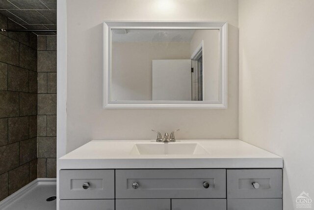 bathroom with vanity and tiled shower