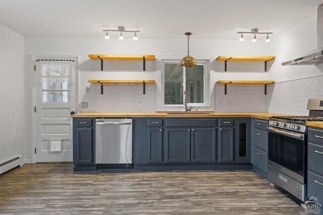 kitchen with wooden counters, appliances with stainless steel finishes, hanging light fixtures, and range hood