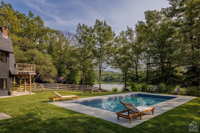 view of swimming pool featuring a yard and a water view