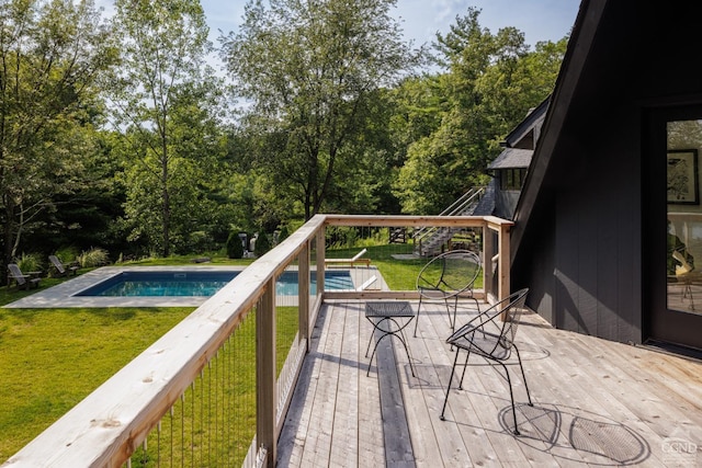 view of swimming pool with a yard and a deck