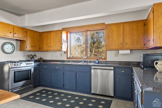 kitchen featuring appliances with stainless steel finishes, light tile patterned floors, and sink