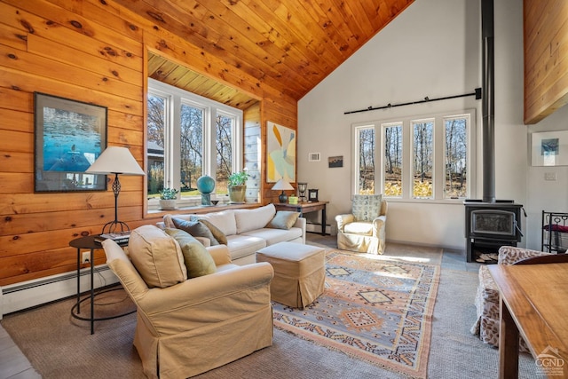 living room featuring plenty of natural light, a wood stove, high vaulted ceiling, and a baseboard radiator