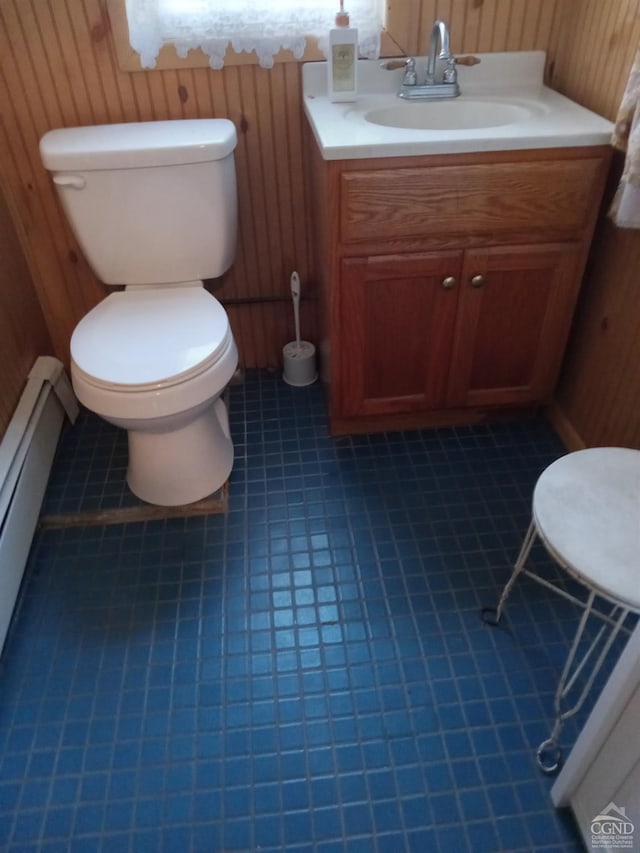 bathroom featuring tile patterned floors, vanity, toilet, and wooden walls