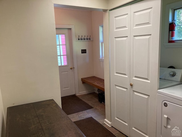 doorway to outside with washer / dryer, dark tile patterned flooring, and plenty of natural light