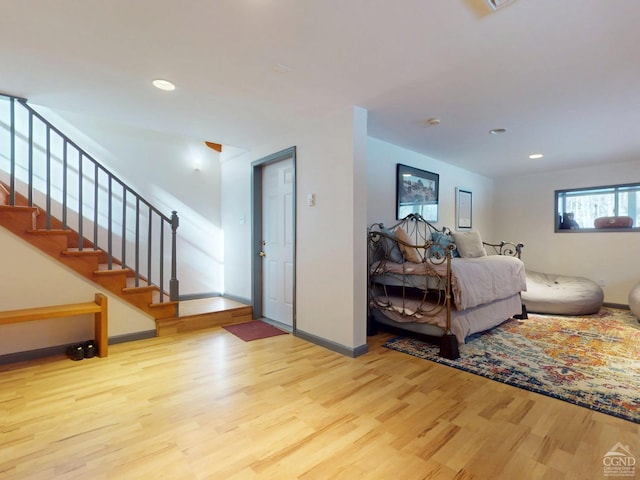 living area with baseboards, stairway, wood finished floors, and recessed lighting