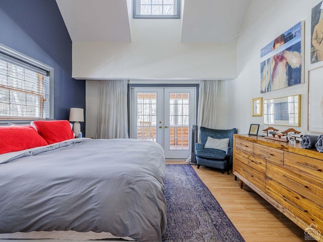 bedroom with access to outside, french doors, multiple windows, and wood finished floors