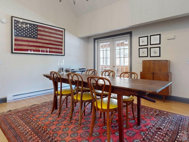 dining room with french doors, a baseboard radiator, vaulted ceiling, wood finished floors, and baseboards