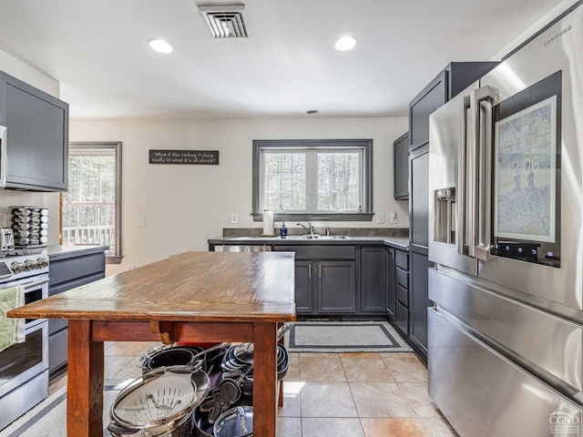 kitchen featuring light tile patterned floors, recessed lighting, visible vents, appliances with stainless steel finishes, and a sink