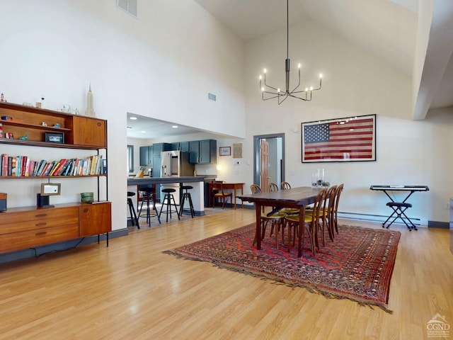 dining area with a chandelier, light wood finished floors, visible vents, and baseboards