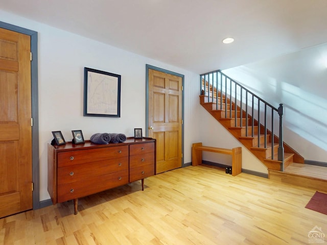 interior space with stairs, wood finished floors, and baseboards