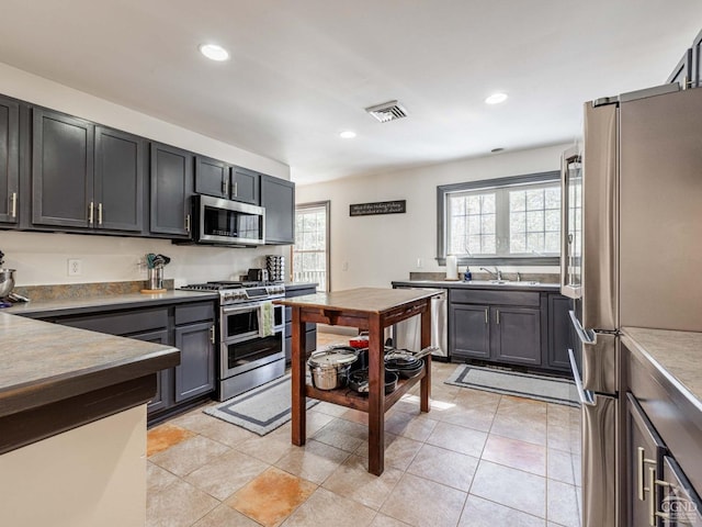 kitchen with light tile patterned floors, visible vents, appliances with stainless steel finishes, a sink, and recessed lighting