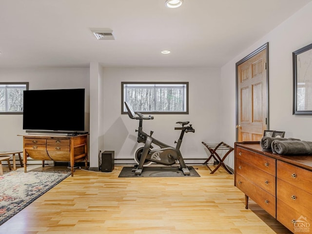 exercise area with a wealth of natural light, visible vents, and light wood finished floors