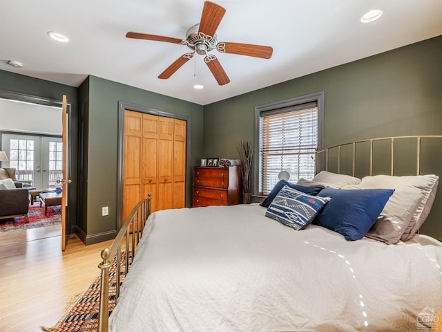 bedroom with a closet, baseboards, wood finished floors, and recessed lighting