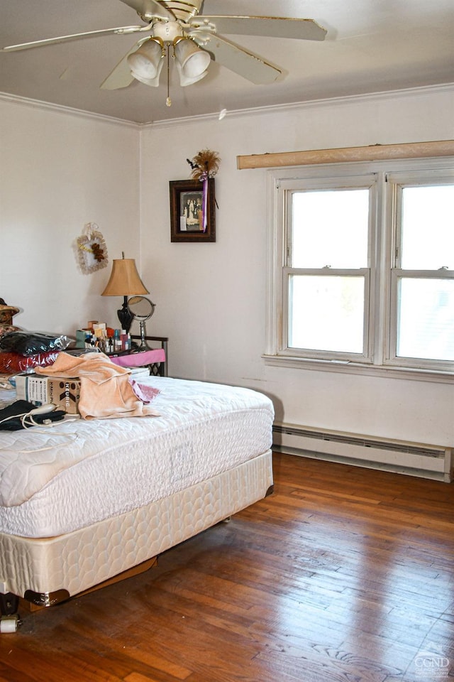 bedroom featuring a baseboard radiator, ceiling fan, ornamental molding, and dark hardwood / wood-style floors