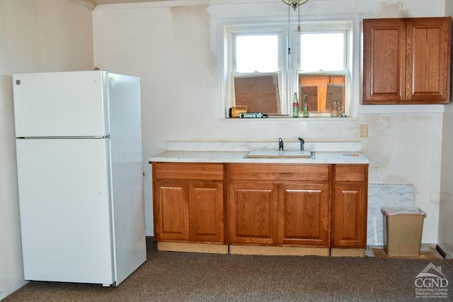 kitchen with white refrigerator, dark carpet, and sink