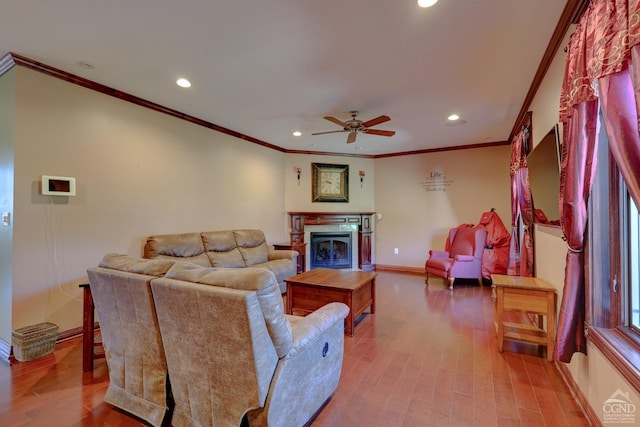 living room featuring hardwood / wood-style floors, ceiling fan, and crown molding