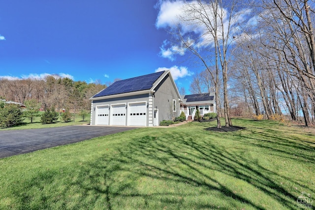 view of side of home with solar panels and a lawn