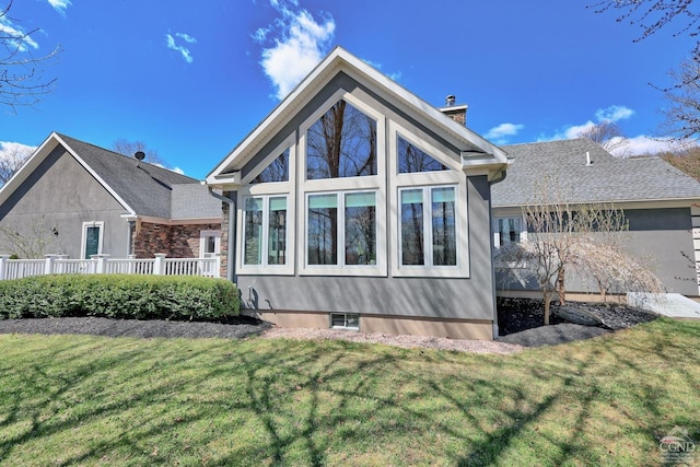 rear view of property featuring a lawn