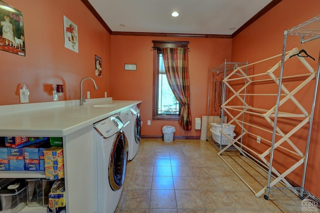 clothes washing area featuring washer and clothes dryer, crown molding, light tile patterned floors, and sink