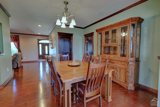 dining space featuring hardwood / wood-style floors, a notable chandelier, and ornamental molding