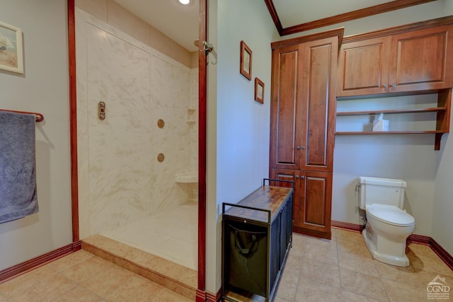 bathroom with a tile shower, tile patterned floors, toilet, and crown molding