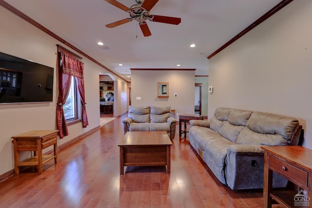 living room with ceiling fan, light hardwood / wood-style floors, and crown molding