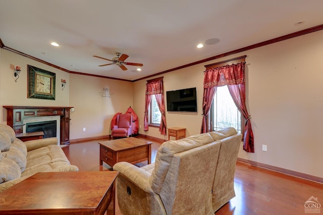 living room featuring light hardwood / wood-style floors, ceiling fan, and ornamental molding